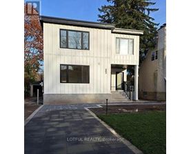 A modern house with a stone walkway in front.