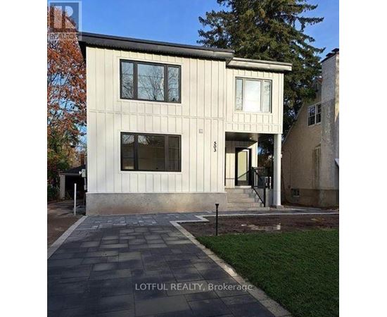 A modern house with a stone walkway in front.
