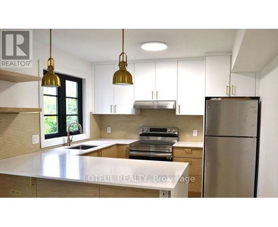 A kitchen with a white countertop and stainless steel appliances.
