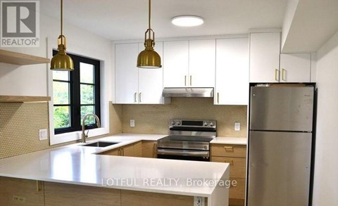 A kitchen with a white countertop and stainless steel appliances.
