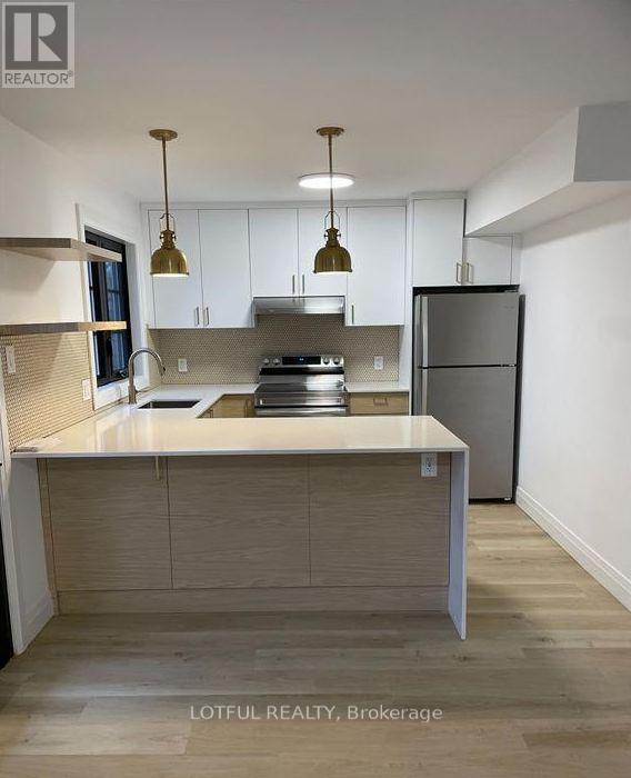 A modern kitchen with a large island and stainless steel appliances.