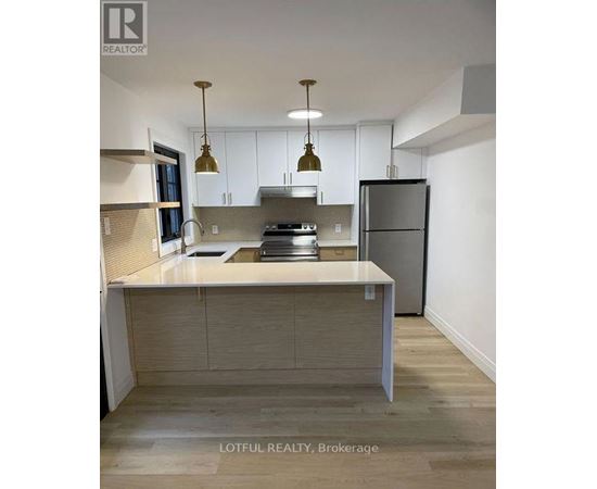 A modern kitchen with a large island and stainless steel appliances.