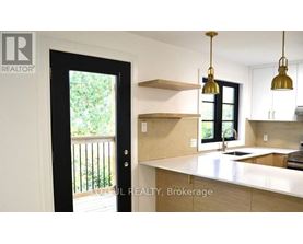 A kitchen with a white countertop and a black door.