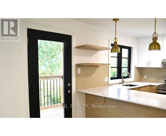 A kitchen with a white countertop and a black door.