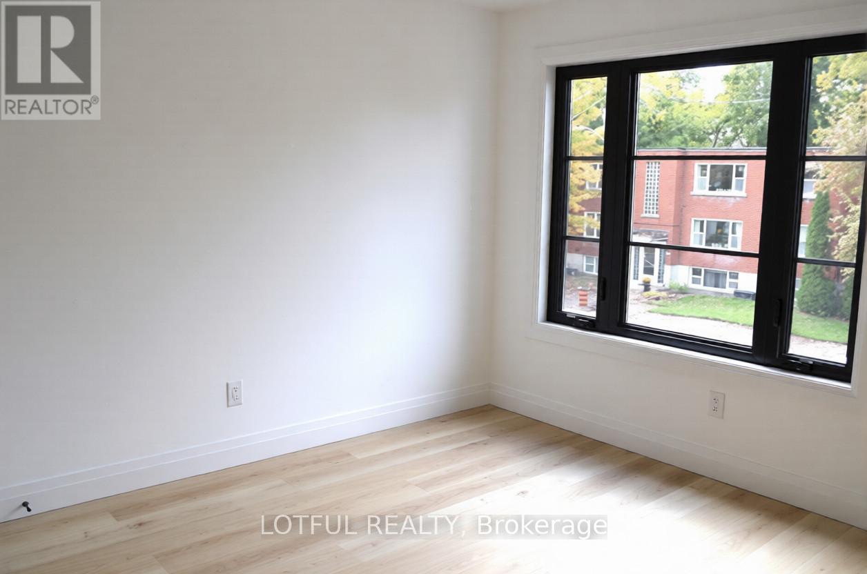 A room with a large window and wooden flooring.