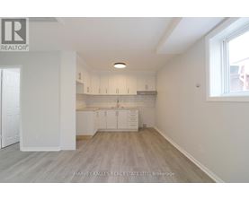 A spacious kitchen with white cabinets and a window.