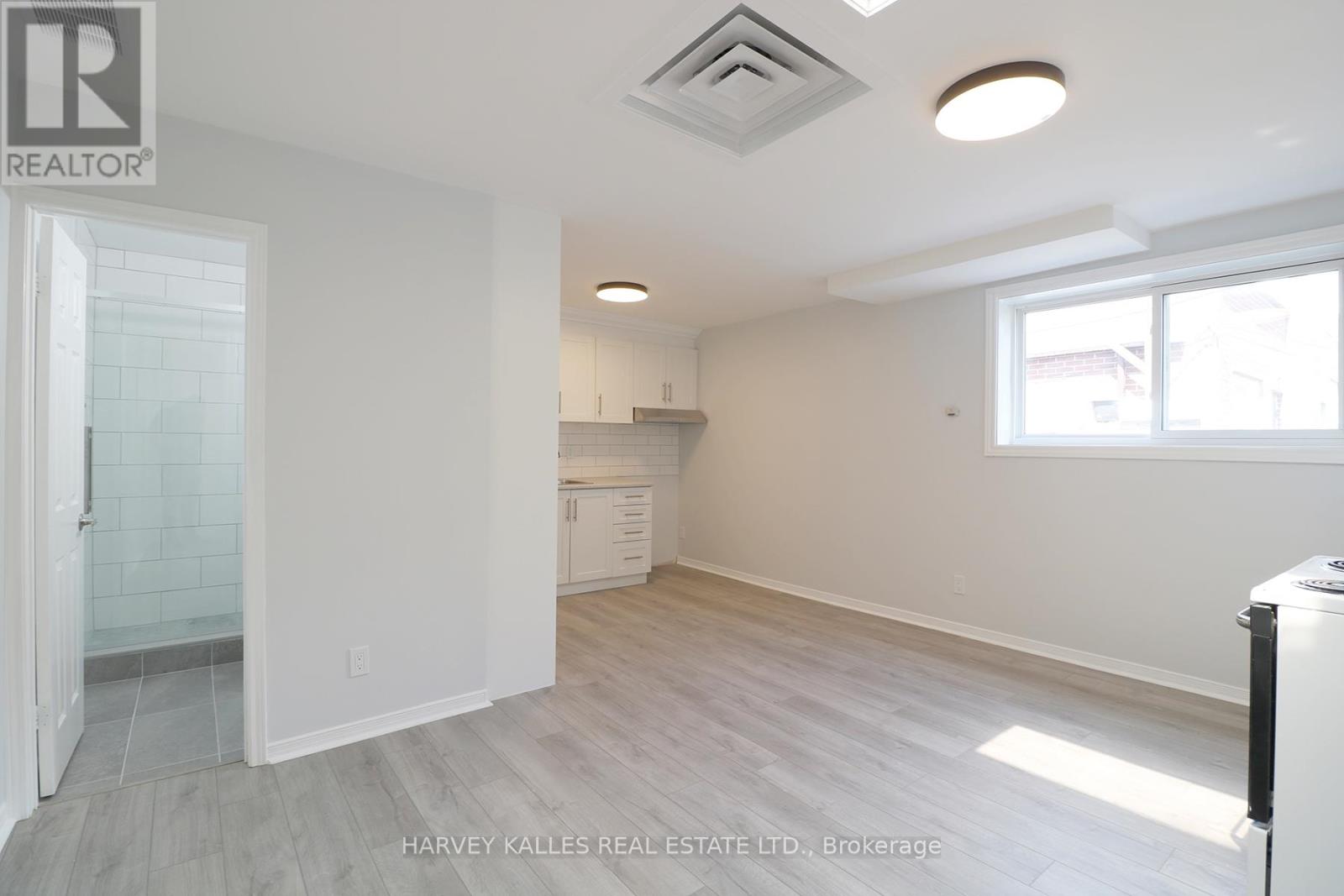 A spacious, empty room with a doorway leading to another room.