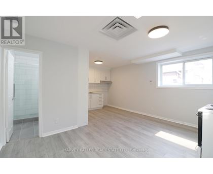 A spacious, empty room with a doorway leading to another room.