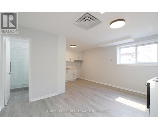 A spacious, empty room with a doorway leading to another room.