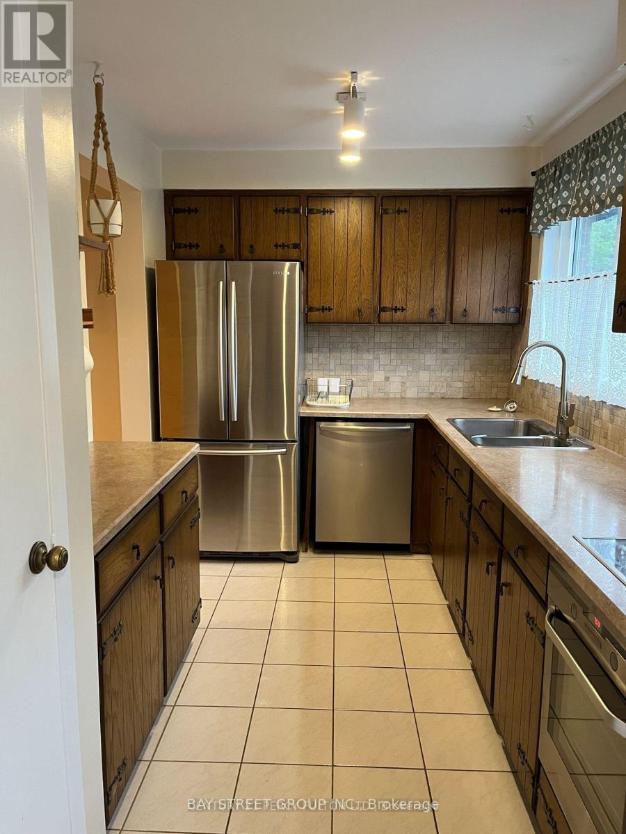 A kitchen with a refrigerator and a sink.