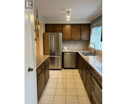 A kitchen with a refrigerator and a sink.