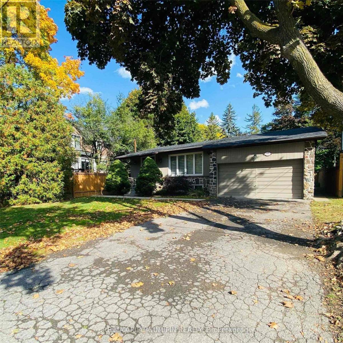 A house with a driveway and trees in the background.
