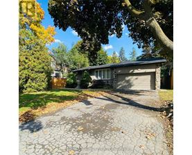 A house with a driveway and trees in the background.