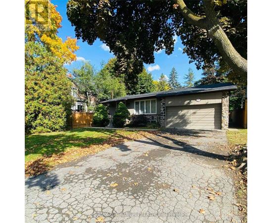 A house with a driveway and trees in the background.