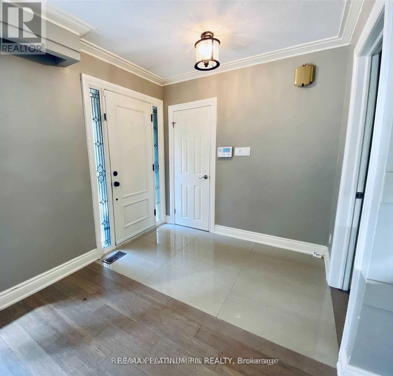 A hallway with a light fixture and two doors.