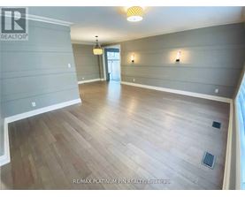 A spacious room with wood flooring and a ceiling light.