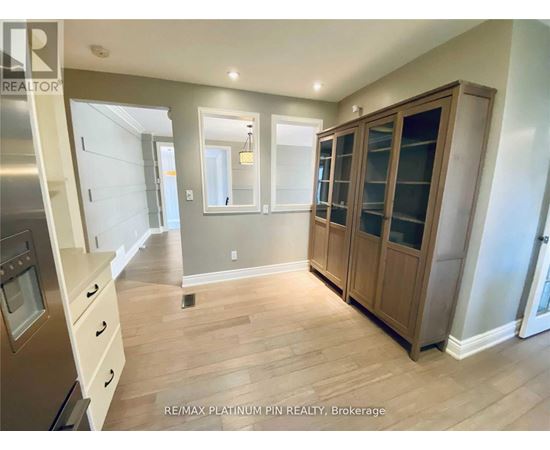 A kitchen with wooden cabinets and a stainless steel refrigerator.