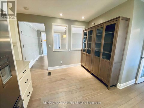 A kitchen with wooden cabinets and a stainless steel refrigerator.