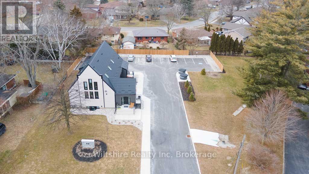 A real estate company's brochure featuring a large house with a driveway and a parking lot.