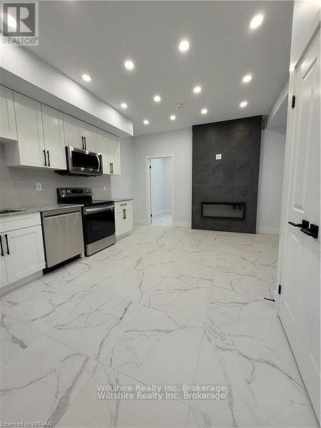 A modern kitchen with a black oven and white cabinets.