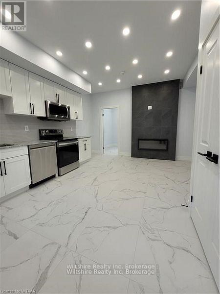 A modern kitchen with a black oven and white cabinets.