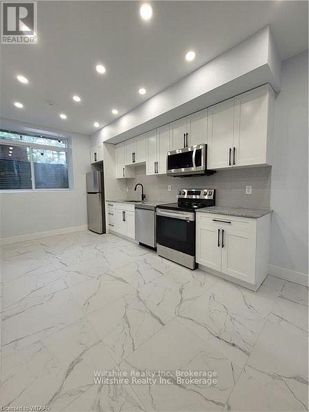 A modern kitchen with white cabinets and appliances.