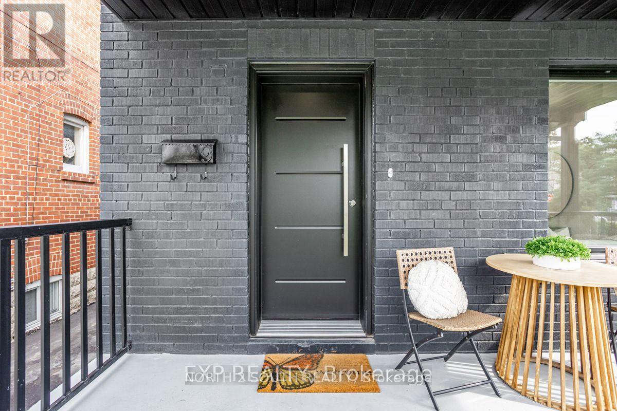A black door is on the left side of a brick wall.