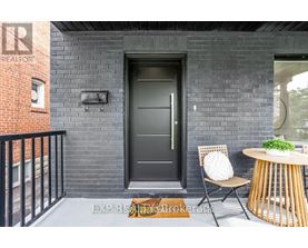 A black door is on the left side of a brick wall.