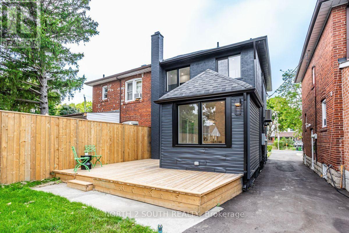 A modern house with a black exterior and a wooden deck.