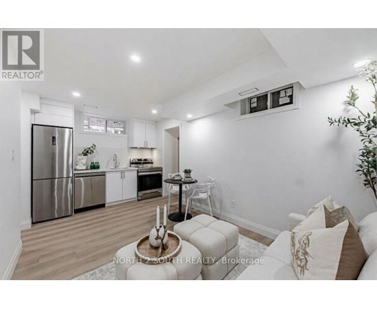 A modern kitchen with stainless steel appliances and a dining area with a round table and chairs.