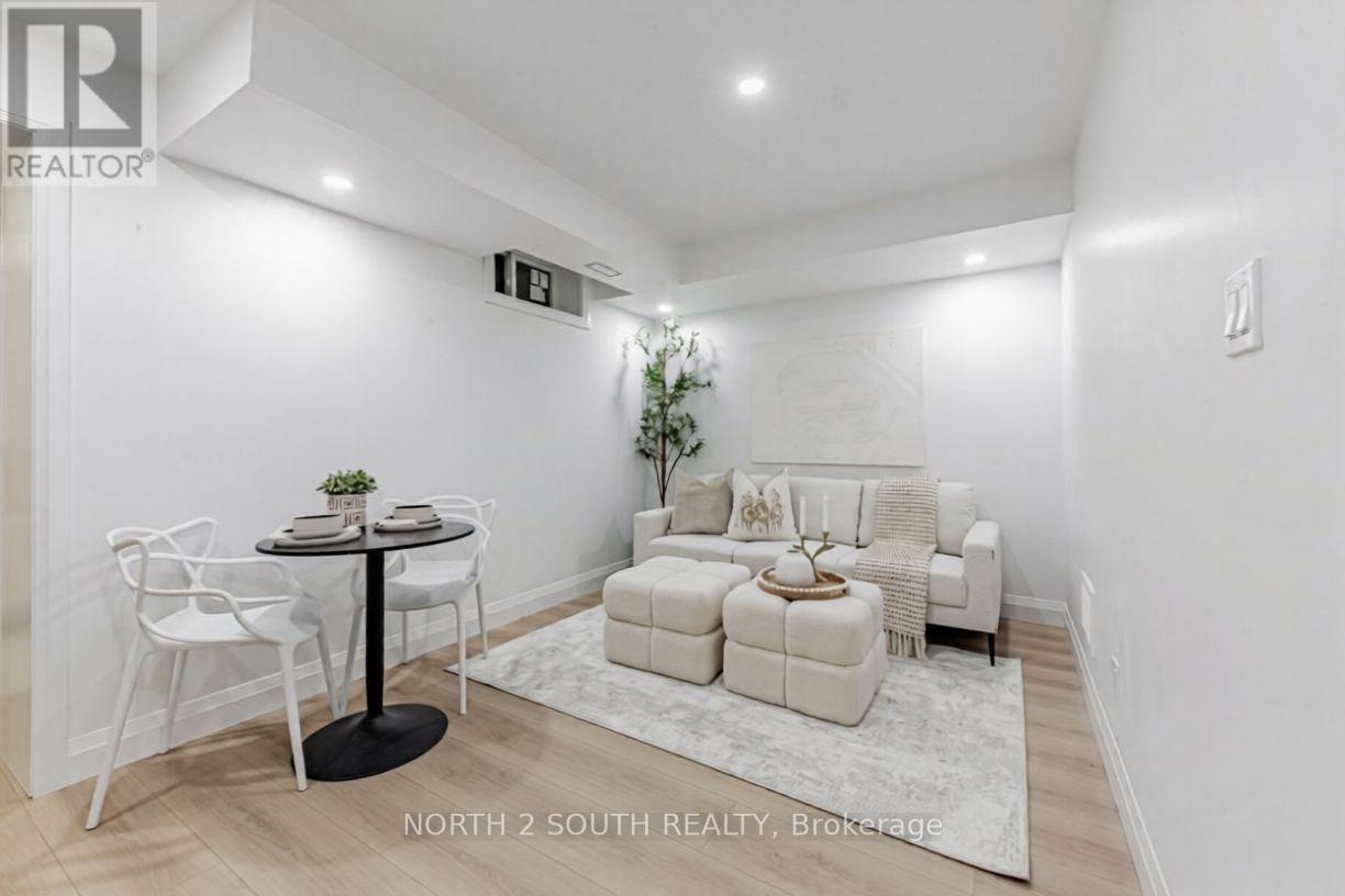 A white dining room with a round table and chairs.