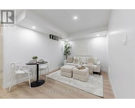 A white dining room with a round table and chairs.