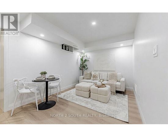 A white dining room with a round table and chairs.