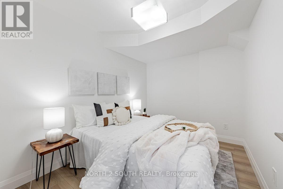 A bedroom with a bed, nightstand, and lamp.