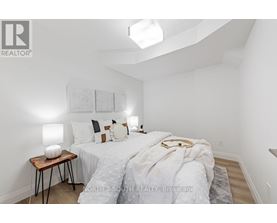 A bedroom with a bed, nightstand, and lamp.