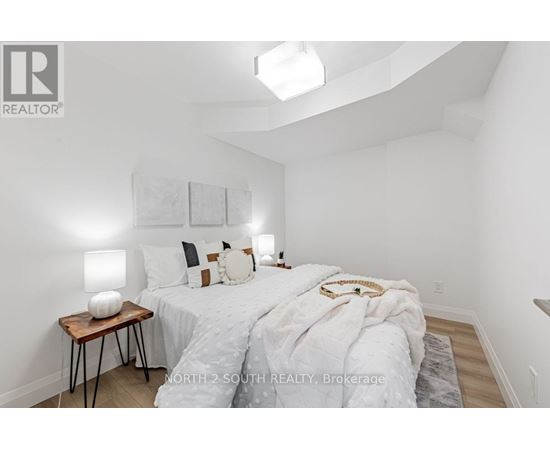 A bedroom with a bed, nightstand, and lamp.