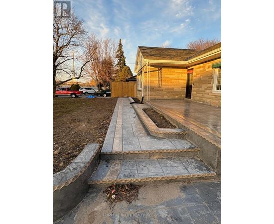 A concrete staircase leads up to a wooden building with a green awning.