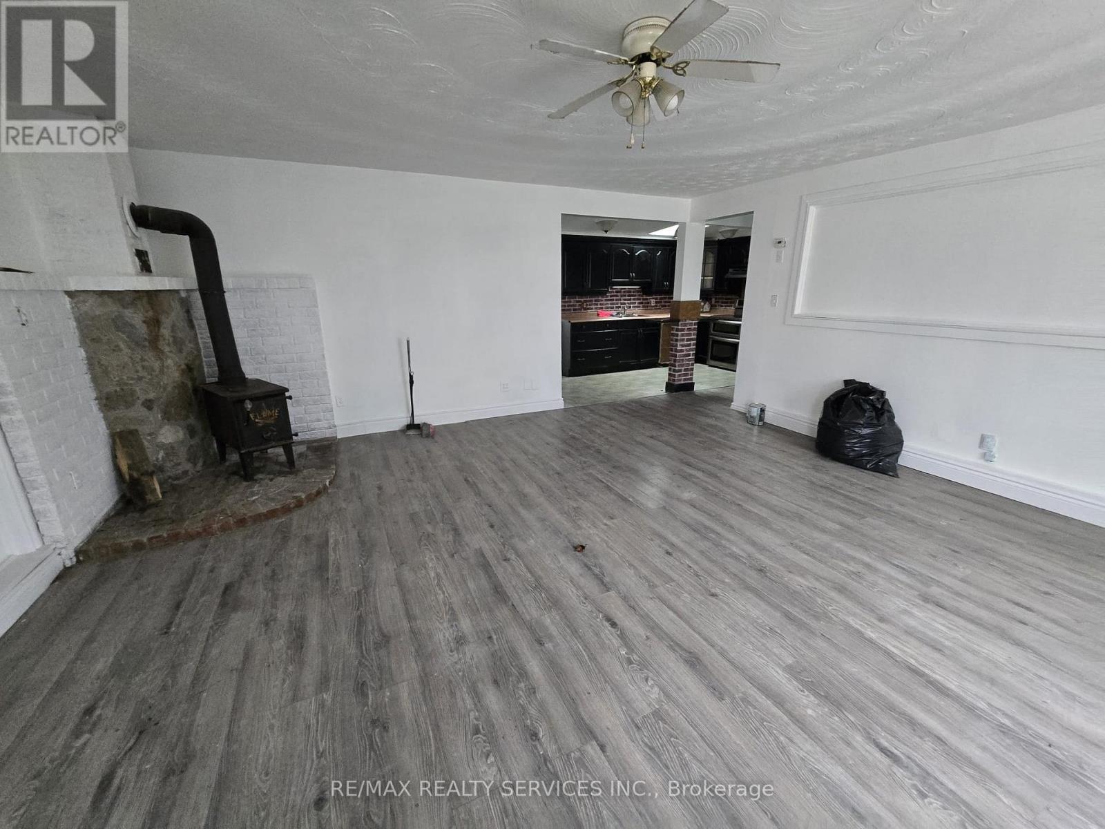 A room with a fireplace and a ceiling fan.