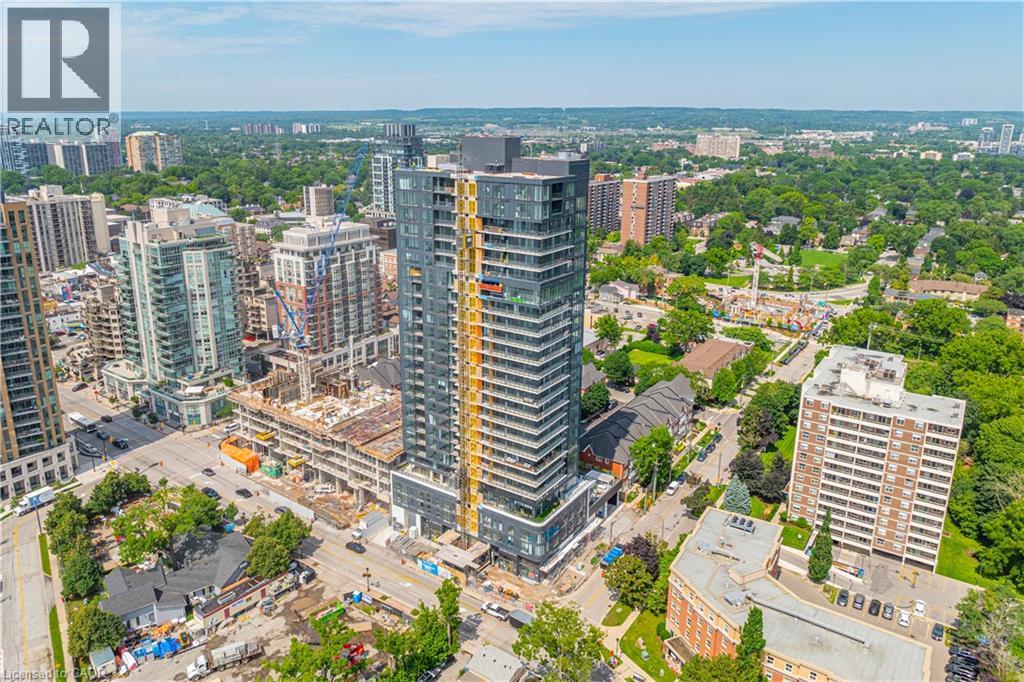 A cityscape with a prominent building in the center and a realtor logo in the corner.