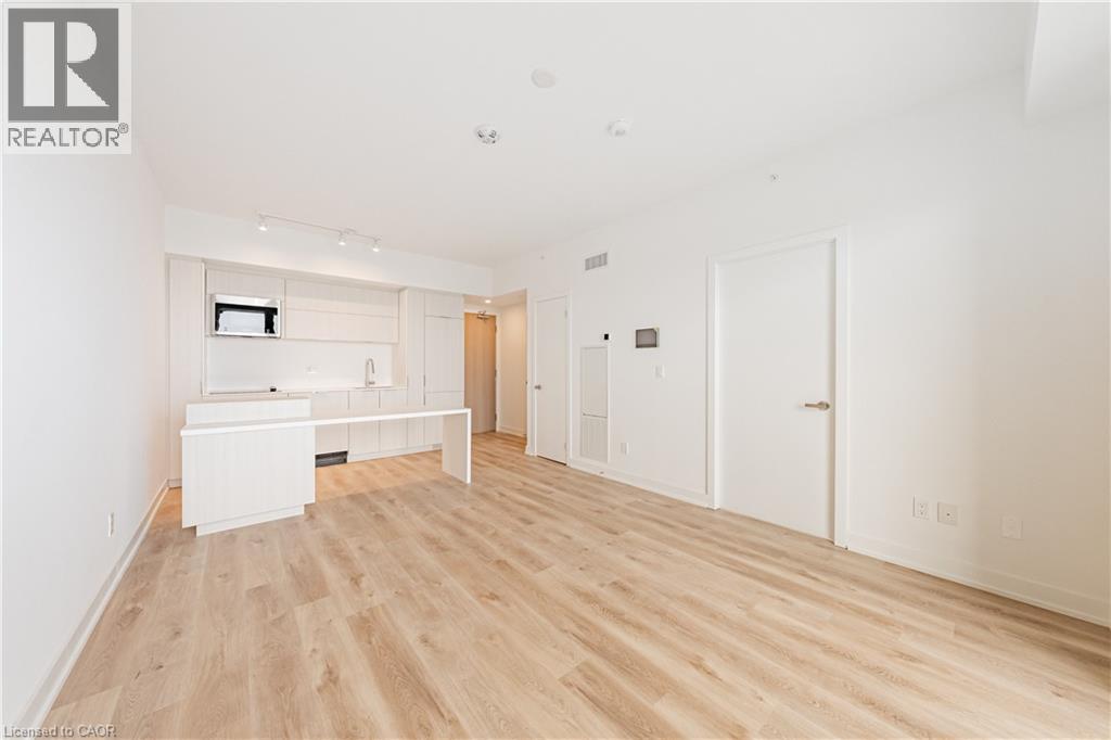 A spacious room with wooden flooring and white walls.
