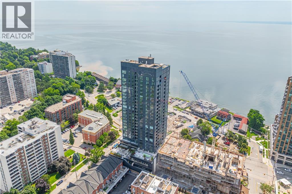 A cityscape with a large body of water in the background and a building under construction in the foreground.