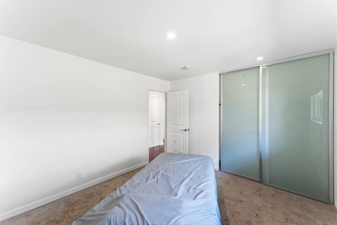 A bedroom with a bed and a glass door.