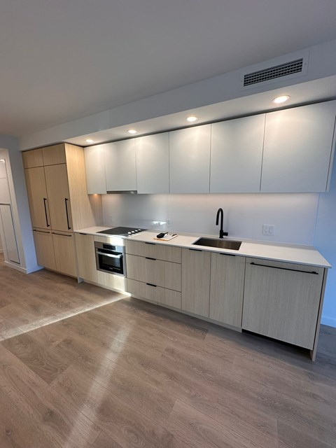 A kitchen with wooden floors and cabinets.