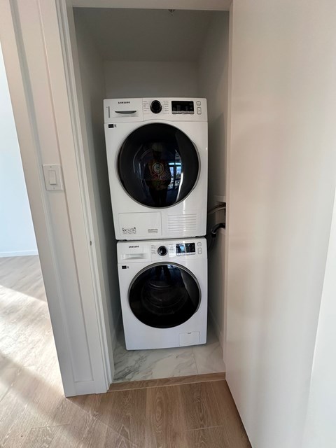 Two white front loading washing machines in a small laundry room.
