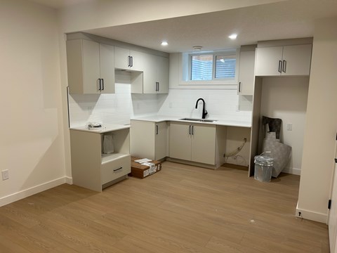 A kitchen with white cabinets and a window.