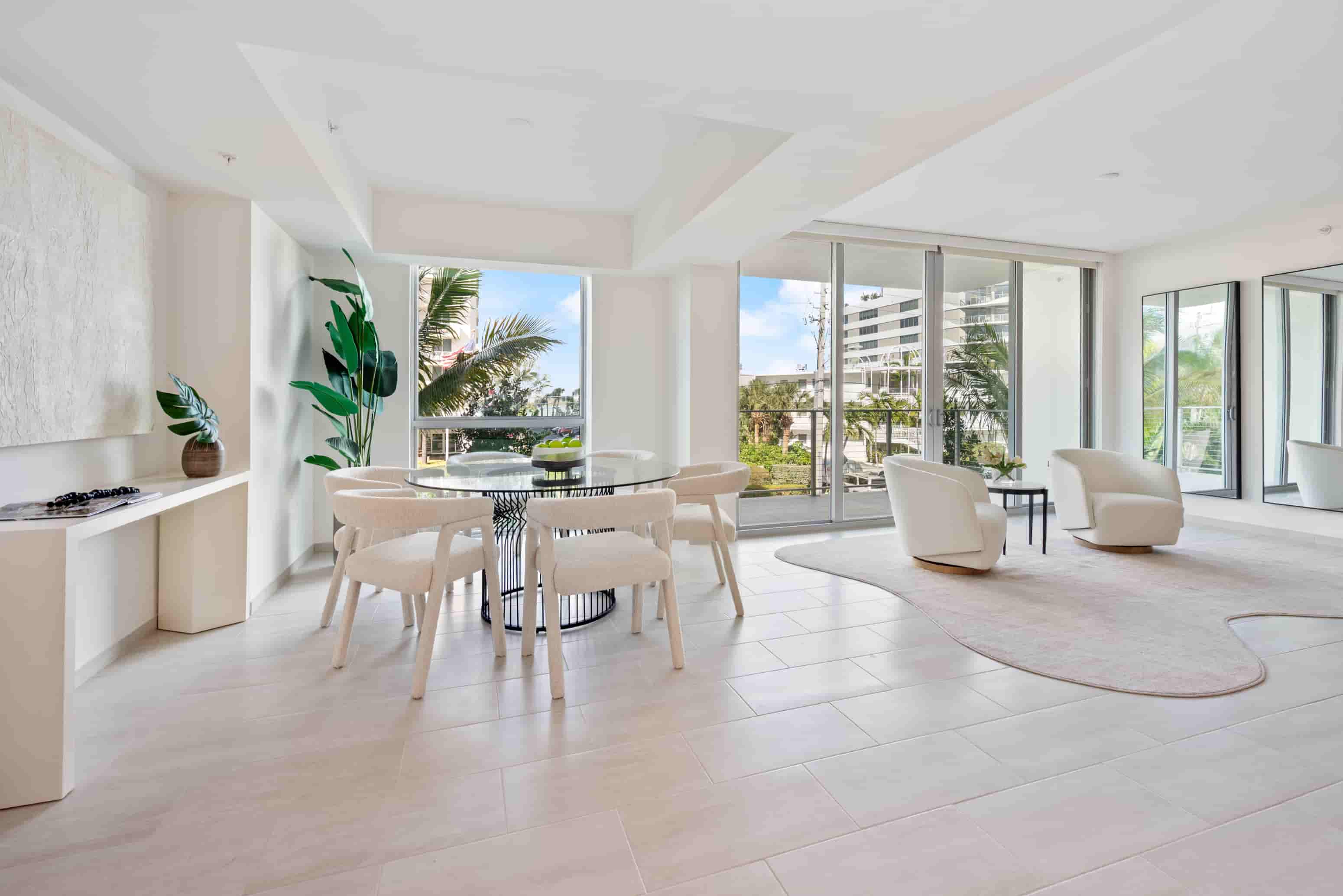 A modern dining room with a glass table and chairs.