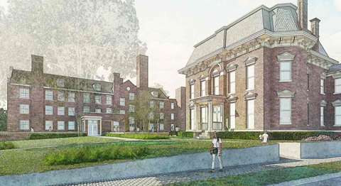 A large red brick building with a green roof and a woman standing in front of it.