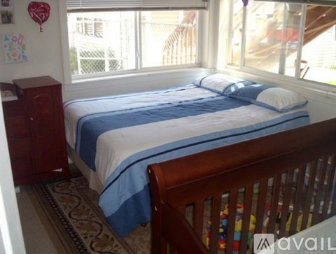 A bedroom with a bed, a dresser, and a window.