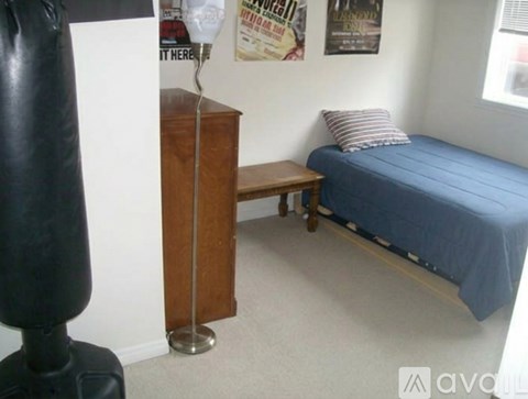 A bedroom with a bed, a bench, and a lamp.