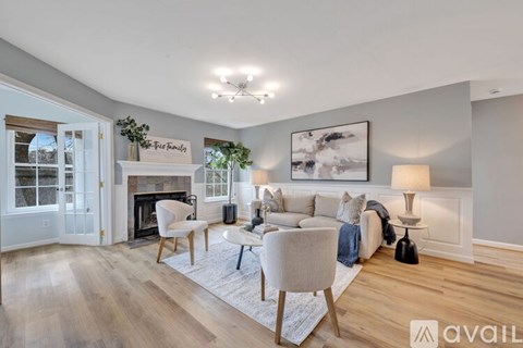 A living room with a fireplace and a painting on the wall.